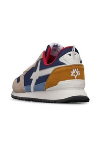 Sneaker med en blandning av material, inklusive marinblå och beige mocka, blå textil och en gul mockadetalj. Vit logotyp och svart sula.