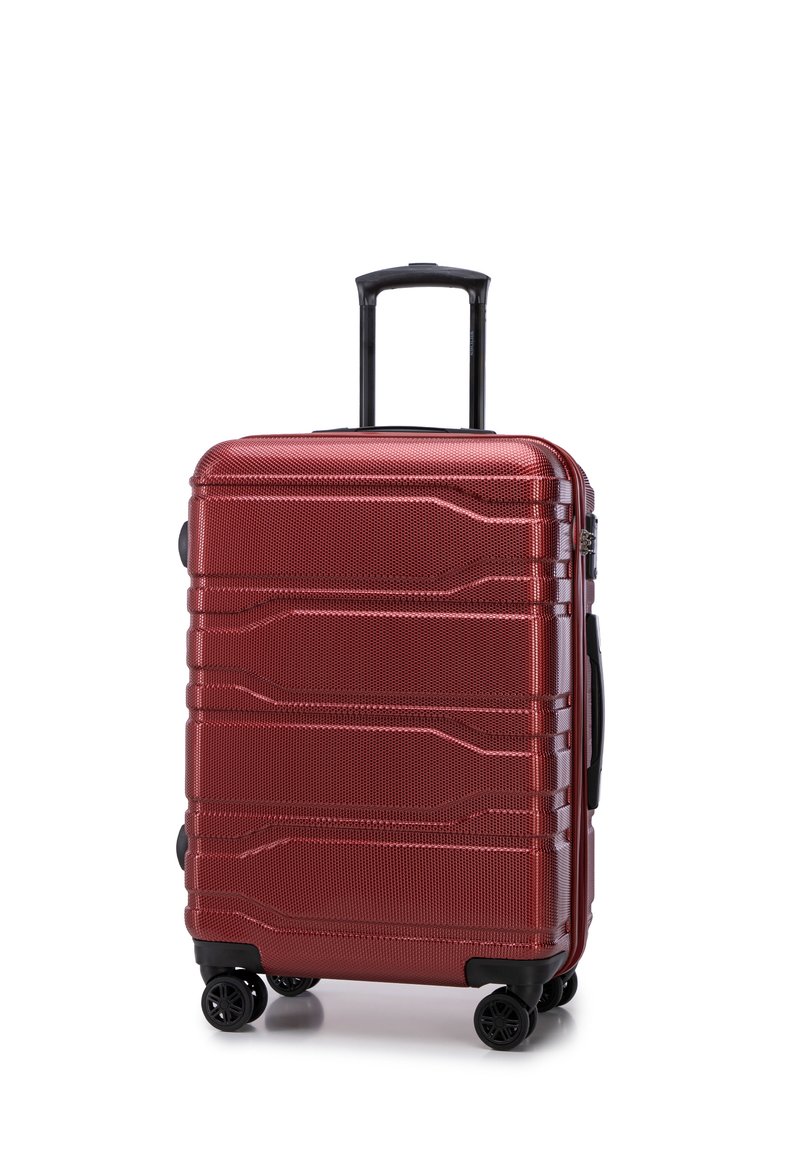 Valise rigide rouge avec une surface texturée, comportant trois lignes horizontales, quatre roues et une poignée rétractable.