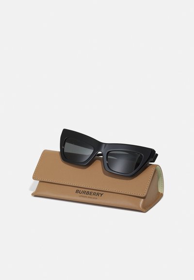 Czarne okulary przeciwsłoneczne w kształcie kociego oka na beżowym skórzanym etui. Etui z czarnym logo Burberry. Gładka tekstura, kanciasty design.