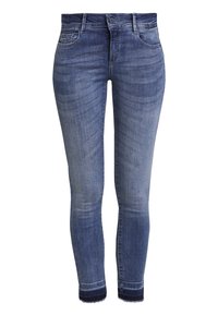 Siniset farkut, joissa on kapeat lahkeet ja haalistunut pesu, viisi taskua, nappi- ja vetoketjusuljenta sekä revitty helma.