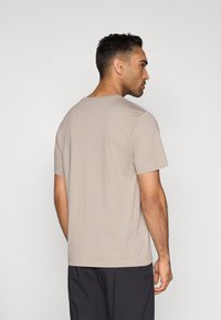 Μπεζ κοντομάνικη μπλούζα κατασκευασμένη από μαλακό ύφασμα. Διαθέτει κλασικό στρογγυλό λαιμό και άνετη εφαρμογή. Ομαλή υφή και απλός σχεδιασμός.