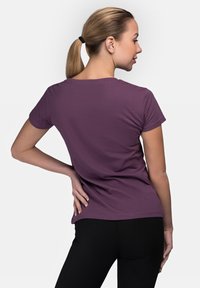 Short-sleeve purple t-shirt with a round neckline, made of soft fabric, smooth texture, and a relaxed fit, viewed from the back.