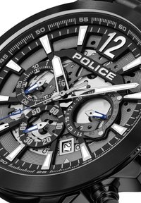 Črna ura z večplastnim številčnico s srebrnimi in modrimi poudarki. Izstopajoče oznake za ure, pomožni številčnice in prikaz datuma ob 6. uri.