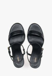 Zwarte leren sandalen met een platte zool, voorzien van brede banden en een enkelgesp. Gladde textuur met een minimalistisch ontwerp.