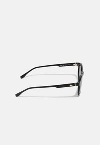 Ochelari de soare dreptunghiulari negri cu accente verzi pe tâmple, având rame din plastic elegante și detalii aurii pe lateral.