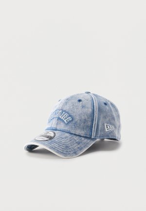 Casquette de baseball en denim avec visière courbée, texte brodé "VOLTAIRE" à l'avant, logo de la marque sur le côté et sangle ajustable à l'arrière.