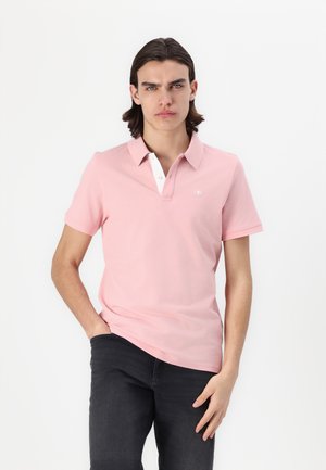 Hellrosa Polohemd mit weißem Kragen und einer Dreiknopf-Leiste. Kurze Ärmel, sanfte Textur und kleines besticktes Logo auf der Brust.