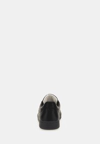 Sneaker in pelle nera con una finitura liscia, punta arrotondata e un interno imbottito. Presenta una fodera e dettagli di cucitura sottili.