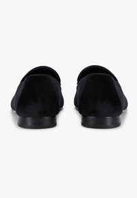 Czarne zamszowe buty wsuwane na niskim czarnym gumowym obcasie. Gładka tekstura z zaokrąglonym noskiem i bez widocznego okucia lub akcentów.