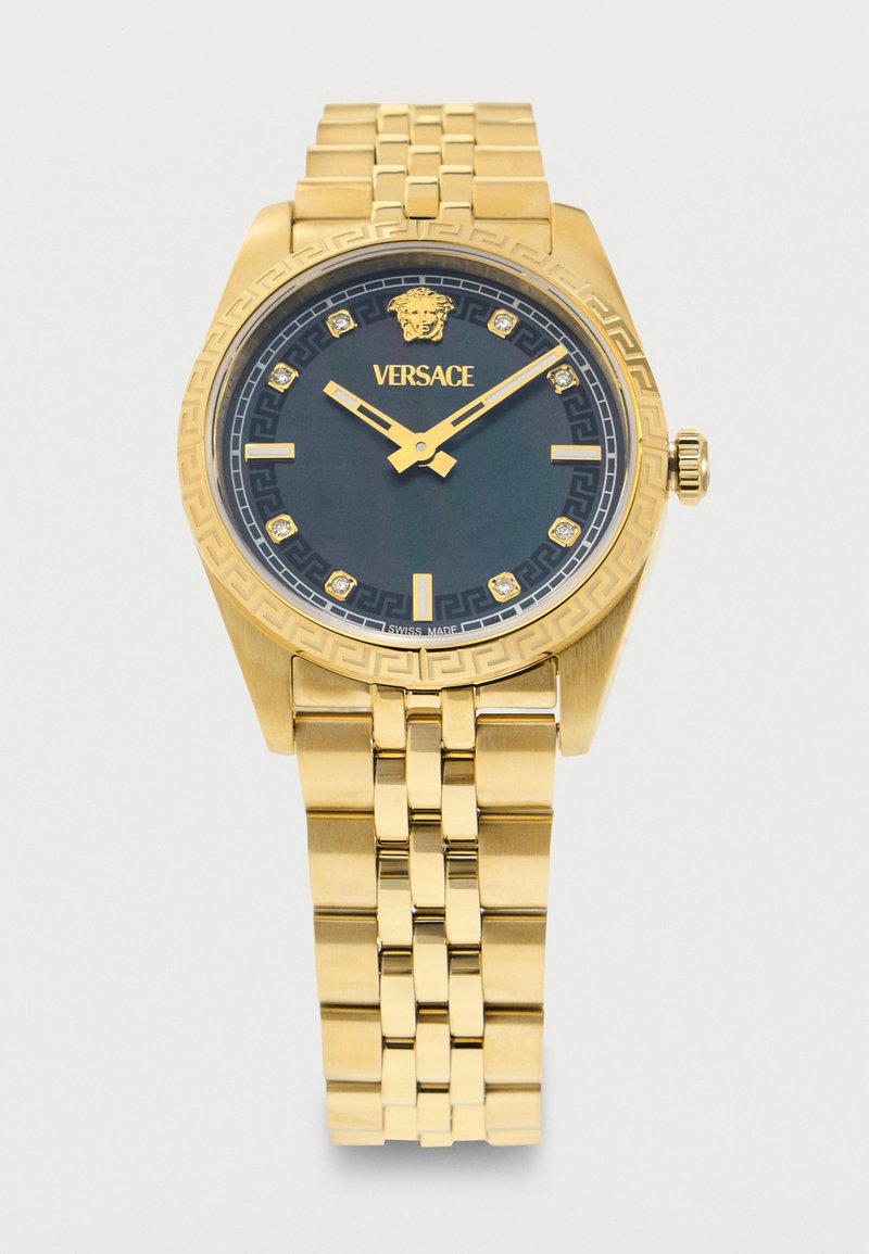 Χρυσό ρολόι Versace με μαύρο καντράν, λογότυπο Medusa, διαμαντένιους δείκτες ώρας, χρυσά δείκτες και μεταλλικό μπρασελέ με συνδέσμους.