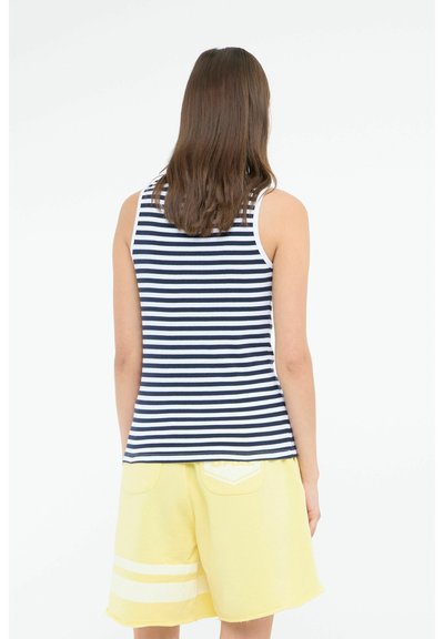 Top de tirantes a rayas en azul marino y blanco, con un diseño ajustado. Combinado con pantalones cortos amarillos con rayas blancas y bolsillos.