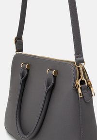 Gray leather handbag with gold hardware, dual top handles, and a zippered closure. Features a smooth texture and structured design.