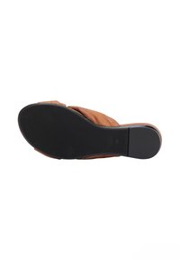 Sandal in pelle marrone con design curvo, punta aperta e suola in gomma nera liscia. Stile minimalista senza hardware visibile.