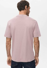 Light pink short-sleeve t-shirt in soft fabric. Straight cut with a crew neckline. Features no visible logos or patterns.