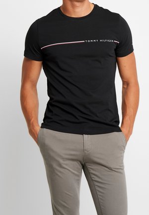 Czarny t-shirt z krótkim rękawem wykonany z bawełny, z białym i czerwonym paskowanym logo na piersi oraz dopasowanym krojem.