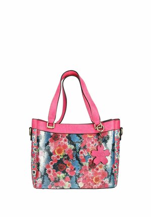 Sac à main rose avec motif floral, double bandoulière et un charm en forme de fleur rose attaché à une des bandoulières.