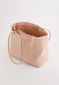 Bolso tote de cuero rosa con un acabado suave, que cuenta con dos asas largas y un forro interior suave. Incluye un bolsillo con cremallera en el interior.