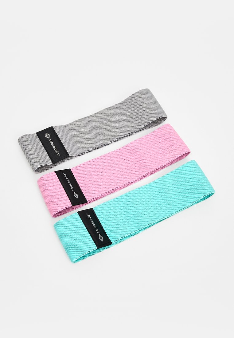 Trois bandes de résistance en tissu d'exercice de couleur grise, rose et turquoise, chacune portant une étiquette noire avec un logo et un texte blancs.
