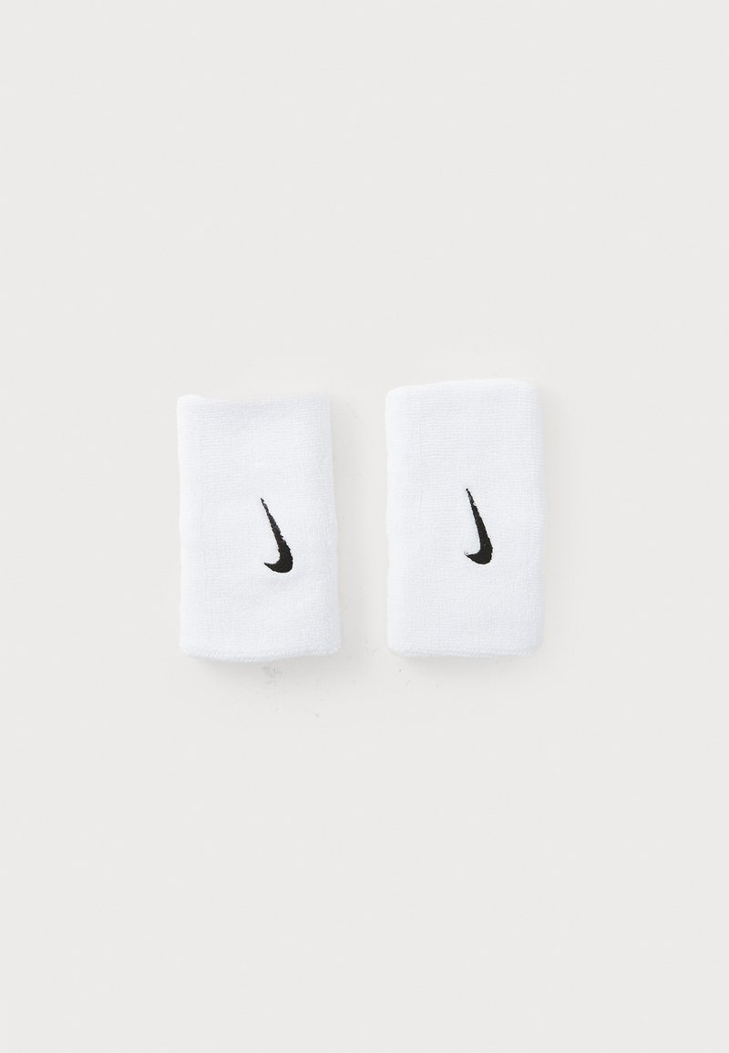 Pár bielych športových náramkov Nike s čiernymi logami Swoosh, umiestnené vedľa seba na jednoduchom bielom pozadí.
