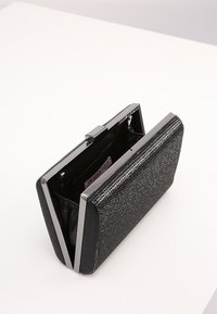 Czarna teksturowana kopertówka z metaliczną srebrną ramką, wyposażona w wewnętrzną kieszeń i marszczoną podszewkę dla łatwego dostępu.