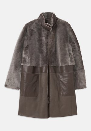 Braune Kunstfell- und Lederjacke mit einem Reißverschluss, hohem Kragen und großen Fronttaschen. Weiche Textur und geschichtetes Design.