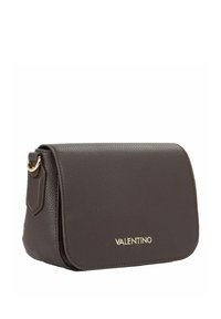 Borsa a patta in pelle marrone con superficie testurizzata, ferrature dorate e logo con marchio sul davanti. Forma rettangolare compatta.