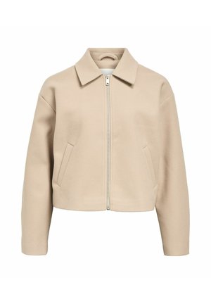Giacca beige corta con colletto piatto, chiusura frontale con zip, due tasche laterali e una texture liscia. Progettata con una vestibilità rilassata e spalle scese.