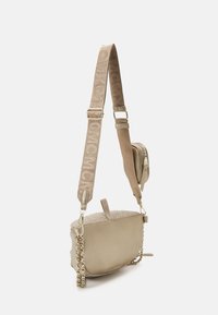 Beige Umhängetasche mit strukturiertem Oberteil, flacher Form und goldfarbenen Kettendetails; verfügt über einen Logo-Tragegurt und ein Reißverschlussfach.