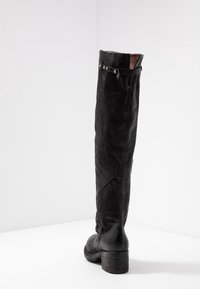 Bota de cuero negra hasta la rodilla con punta redonda, acabado texturizado, cremallera lateral y herrajes decorativos en plata en la parte superior.