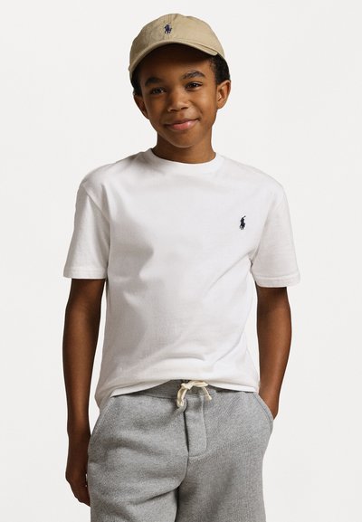 T-shirt en coton blanc avec un petit logo marine sur la poitrine, associé à un pantalon de jogging en coton gris avec taille à cordon et poches latérales.