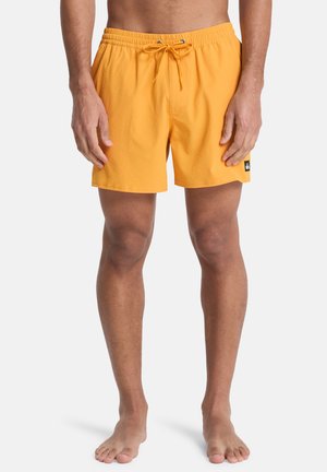 Bañador amarillo con cintura elástica y cordón. Cuenta con una tela texturizada y un pequeño parche de logo negro en el lateral.