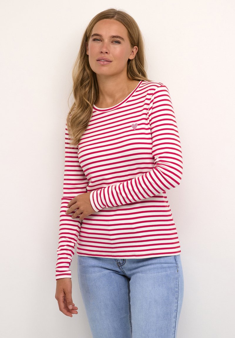 Rood-wit gestreept langemouwen shirt met een ronde hals en een klein hartembleem op de borst. De stof lijkt glad en licht van gewicht.
