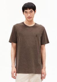 Braunes Baumwoll-T-Shirt mit klassischem Rundhalsausschnitt, kurzen Ärmeln und einem kleinen Logo-Detail auf der linken Brust, das eine lockere Passform bietet.