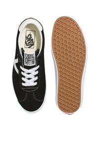 Black suede sneakers with white laces and stitching. Rubber sole with a honeycomb pattern. Logo on the tongue. Classic design with a low profile.