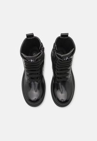 Bottines en cuir verni noir à bout rond, avec un laçage à l'avant, une fermeture éclair sur le côté et un doublage en tissu ; dotées d'un talon renforcé et d'un logo en relief.