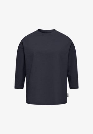 Marineblaues Langarmshirt mit Rundhalsausschnitt, lockerer Passform und einem kleinen schwarz-weißen Markenschild an der unteren Seitennaht.