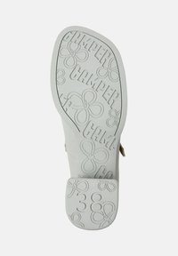 Sula av vit sandal med "CAMPER" logotyp, blommönster och storleksnummer 38 embossat på hälen.