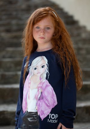 Maglietta a maniche lunghe blu navy con un design di una ragazza dei cartoni animati con capelli rosa, che indossa una giacca rosa. La scritta "TOP Model" in strass sul fondo.