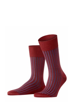 Rote Socken mit lila und blauen vertikalen Streifen, die einen gerippten Abschluss haben, zusammen vor einem weißen Hintergrund präsentiert.