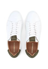 Weiße Ledersneaker mit grünen Wildlederakzenten an der Ferse. Sie verfügen über flache Schnürsenkel, einen gepolsterten Schaft und ein braunes Innenfutter. Branding auf der Zunge und der Innensohle.