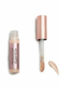 Revolution Super Size Conceal & Define i en klar beholder med en roseguldkappe, der har en blød applikator og en lys beige cremestrimmel.