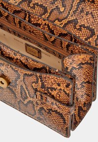 Ruda ir oranžinė gyvatės rašto odinė rankinė su tekstūruota paviršiumi, auksinėmis detalėmis ir vidine užtrauktuko kišene.