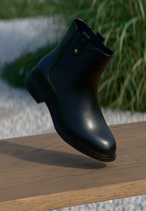 Musthave nahkasaapad mustas värvitoonis, sujuva tekstuuriga, elastsete külgpanelidega ja väikese kuldse aktsendiga saabaste suul. Kerge, läätsest kogutud konts.