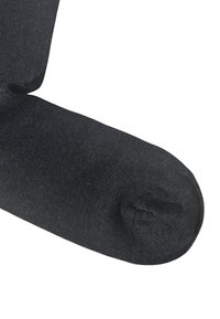 Calzino alla caviglia nero realizzato in tessuto elastico e testurizzato. Presenta una zona della punta liscia e un leggero segno di usura sul lato inferiore.