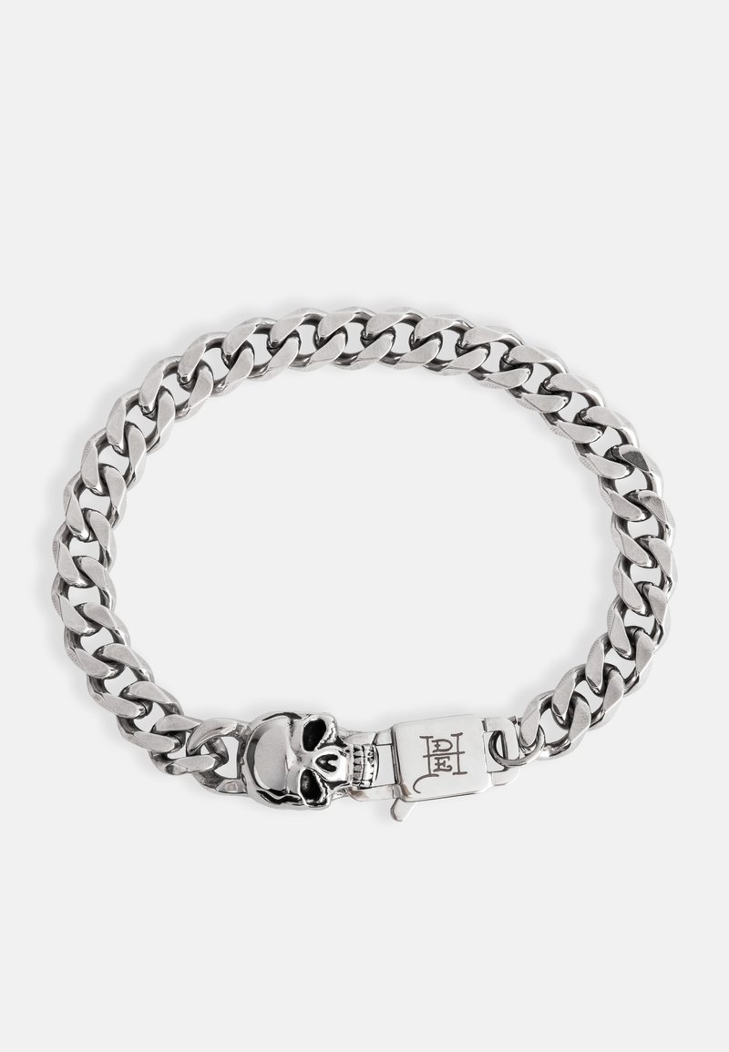 Zilveren metalen kettingarmband met grote schakels, een doodshoofdsluiting en gegraveerde details op de sluiting. Gladde textuur en glanzende afwerking.