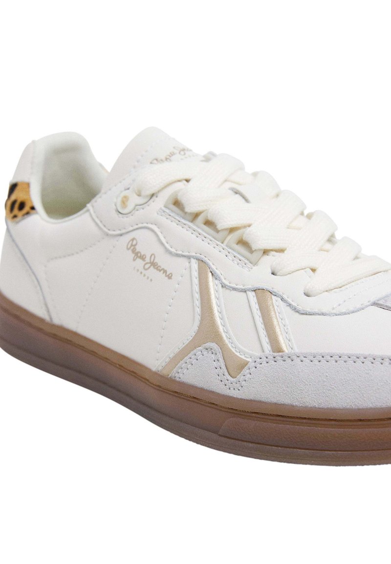 Zapatillas blancas con una parte superior de cuero liso, acentos dorados y suelas texturizadas en tonos marrón claro. Presenta un detalle de estampado de leopardo en el talón.