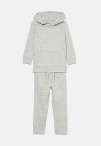 Grijze hoodie met een voorzak en brede hals, gecombineerd met bijpassende sweatpants met een elastische tailleband en trekkoord. Zachte textuur.
