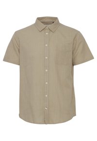 Camisa de manga corta, color marrón claro, hecha de una tela suave. Presenta un collar tradicional, botones en el frente y un único bolsillo en el pecho.