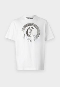 Hvid bomulds t-shirt med et stort sølvfarvet rundt grafisk tryk med en slange og teksten "JUST CAVALLI" i midten. Korte ærmer, rund hals.