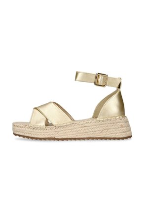 Sandalia espadril de cuña con tiras cruzadas doradas, hebilla en el tobillo y suela plataforma trenzada de yute para un uso casual en verano.